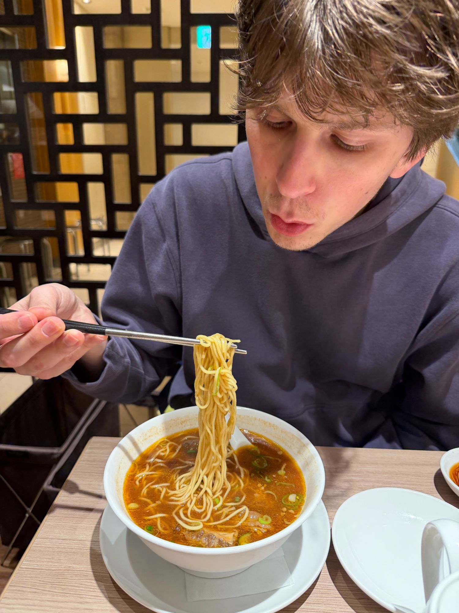 Calvin eating braised beef noodle soup
